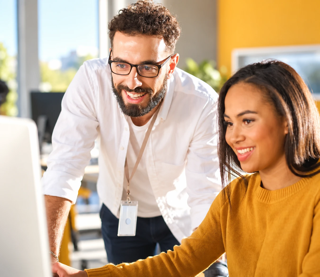 Homem sorrindo ao lado de uma colega de trabalho